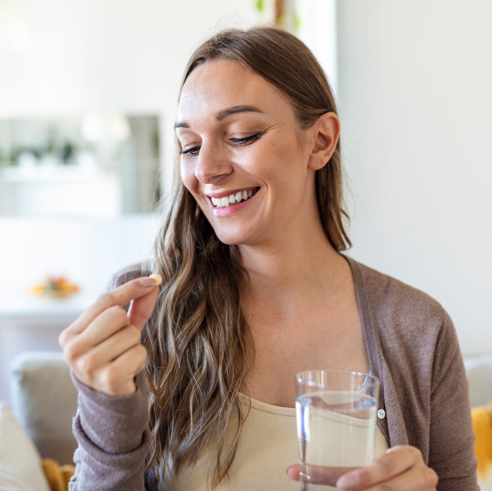 Eternal Health Solutions - Head shot portrait happy woman holds pill glass of water, takes medication